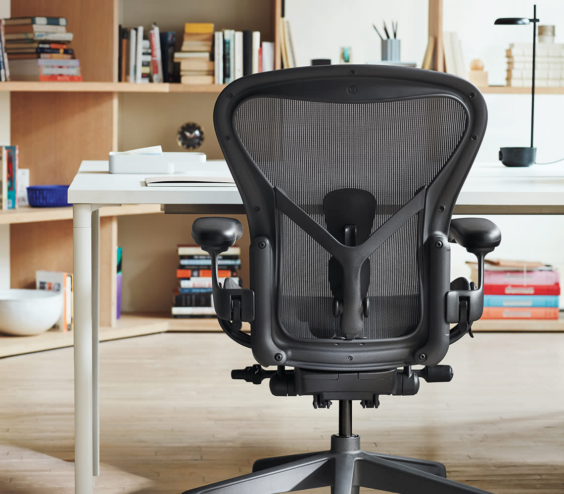 A black office chair situated in front of a desk, creating a functional and organized office setup.